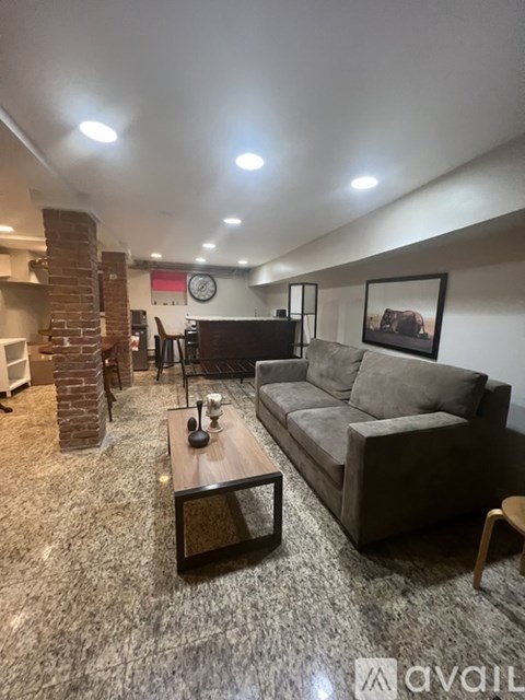 A living room with a grey couch and a fireplace.