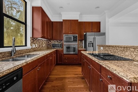 A kitchen with wooden cabinets and granite countertops.