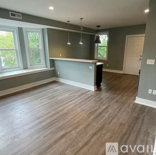 A room with a grey counter and wooden flooring.