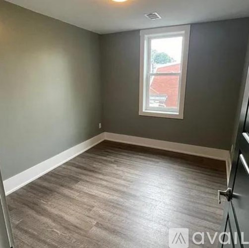 A room with a window and grey walls.