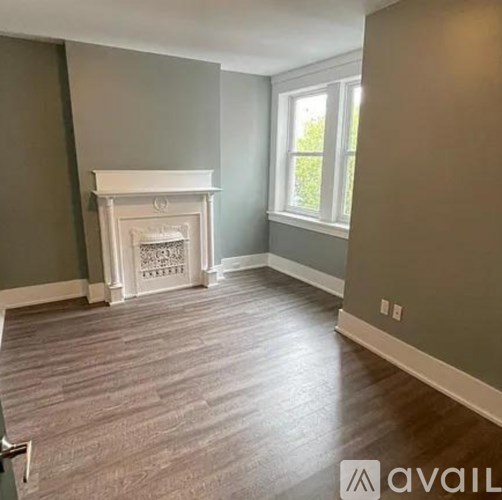 A room with a fireplace and wood flooring.