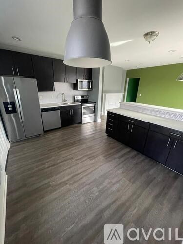 A kitchen with a refrigerator, microwave, and oven.