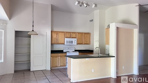 A kitchen with wooden cabinets and a black countertop.