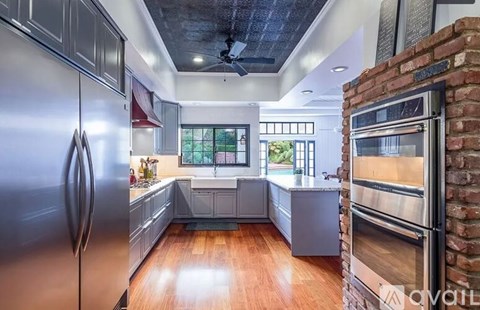 A kitchen with a refrigerator on the left and an oven on the right.