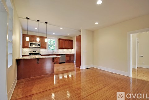 A kitchen with wooden floors and a countertop with a microwave and oven.