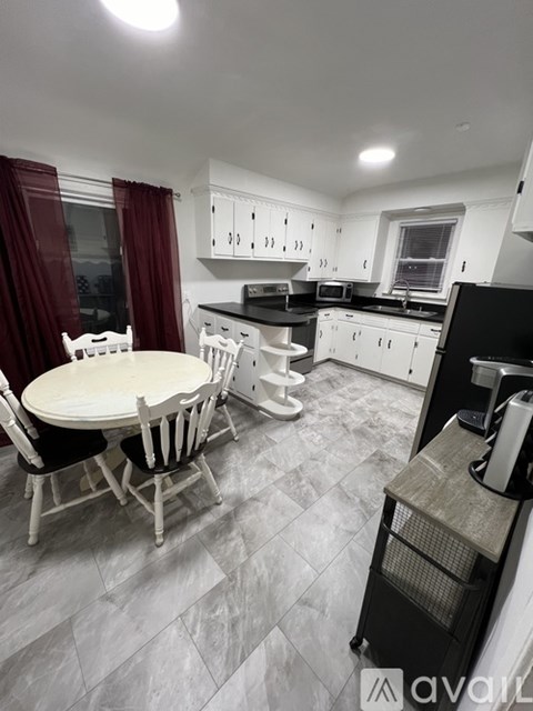 A kitchen with a table and chairs.