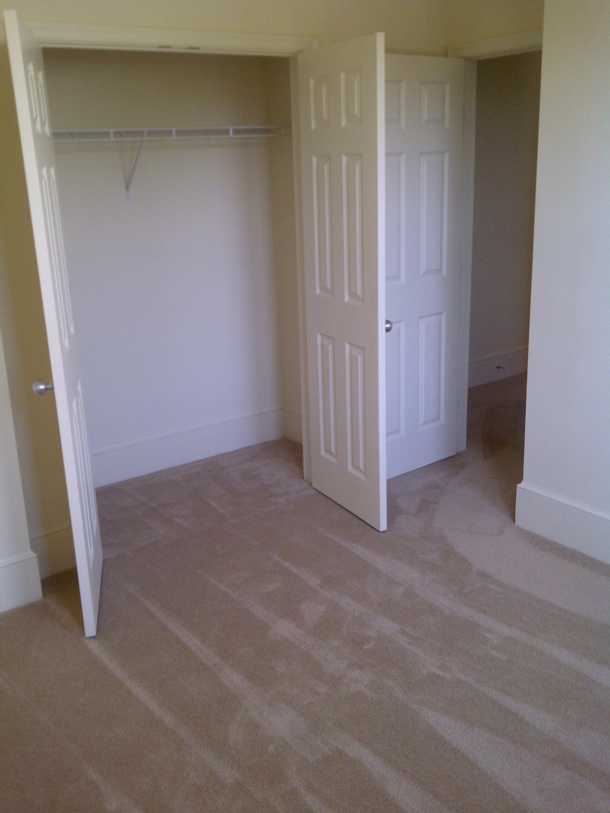 an empty room with a closet and a door