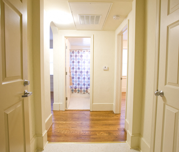 a hallway with white doors and a window with a curtain