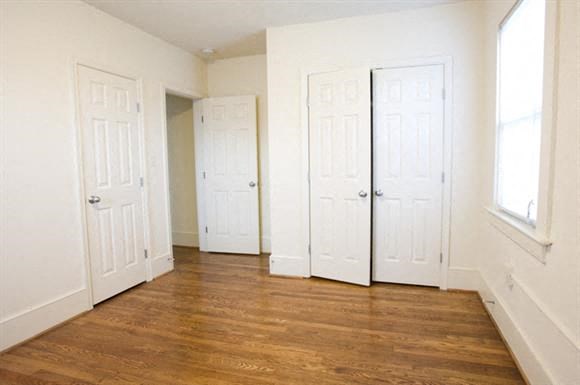 a empty room with three doors and a wood floor