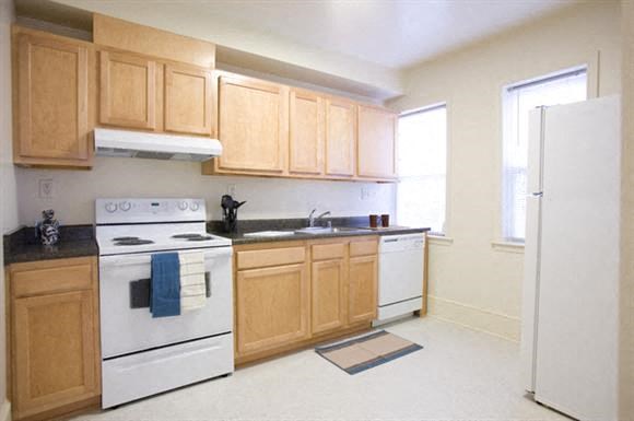 a kitchen with white appliances and wooden cabinets