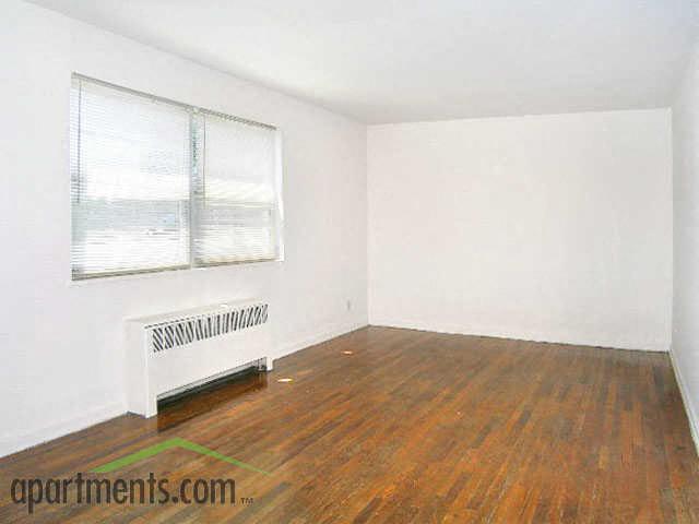 an empty room with a wood floor and a window