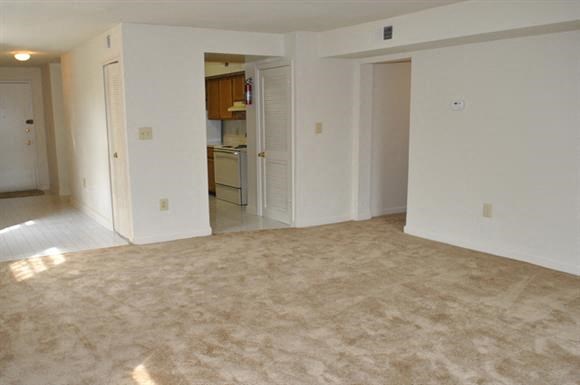 an empty living room and a kitchen in an empty house