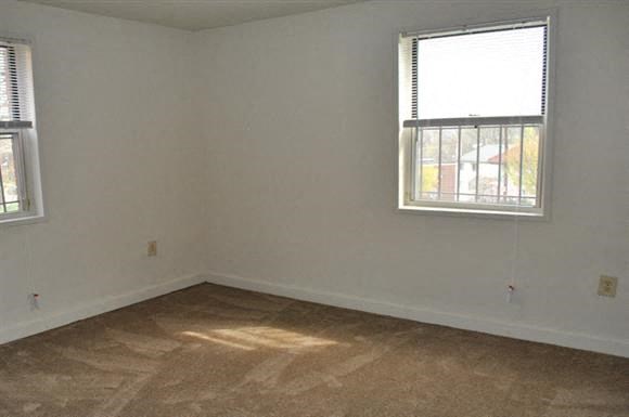 an empty room with two windows and a tiled floor