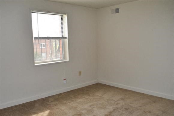 an empty room with a window and a tiled floor