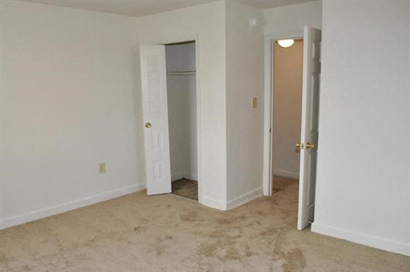 an empty living room with a door to a closet