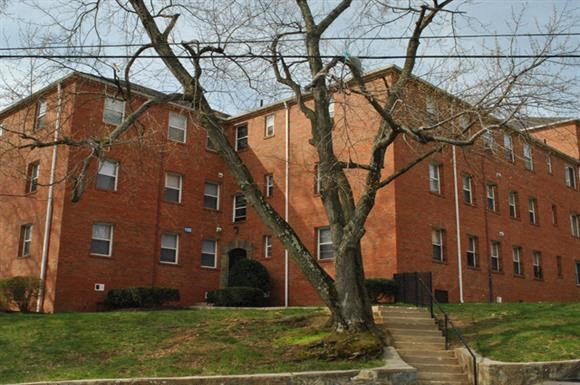 a red brick building with a tree in front of it