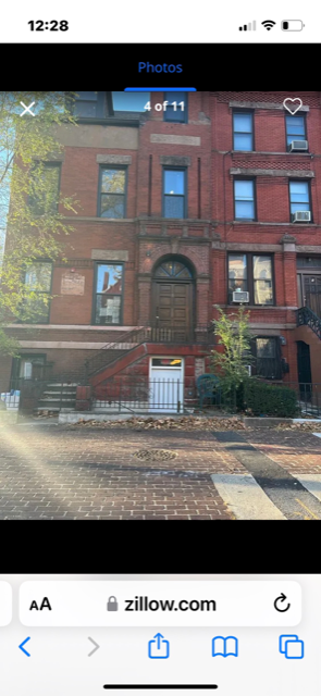 A red brick building with a white door and windows.