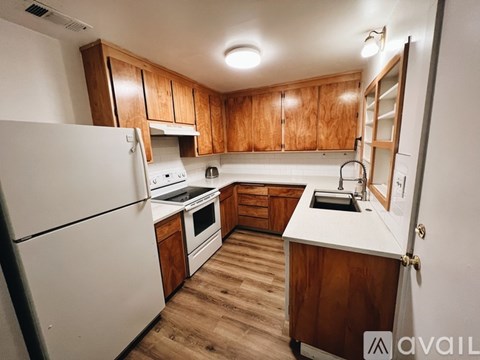 A kitchen with wooden cabinets and a white refrigerator.