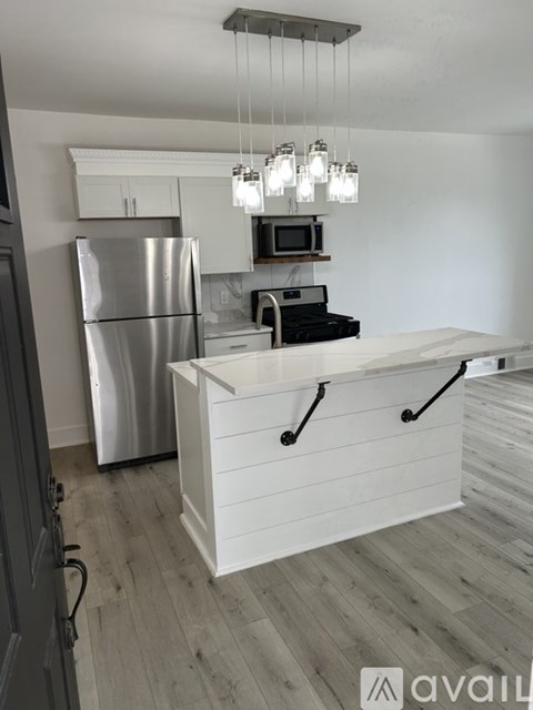 A kitchen with a refrigerator, microwave, and a counter with a drawer.