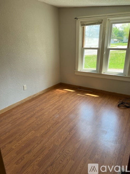 A room with wooden flooring and a window.