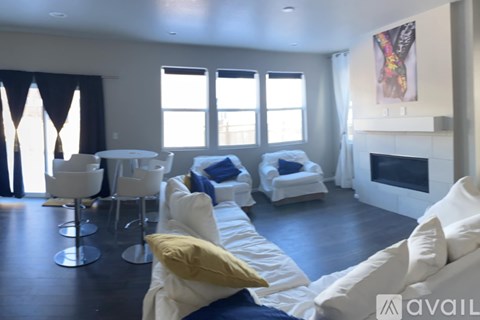 A living room with white furniture and a fireplace.