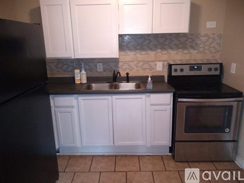 A kitchen with black appliances and white cabinets.