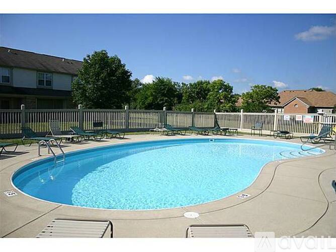 A small pool with a concrete edge and a concrete patio.