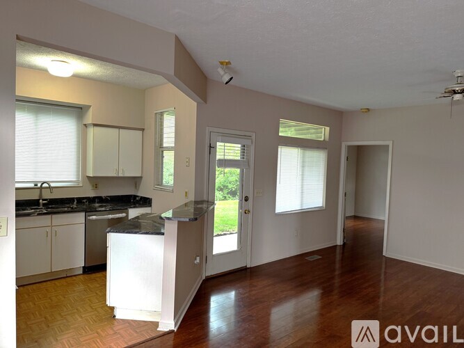 A kitchen with a refrigerator, sink, and cabinets.