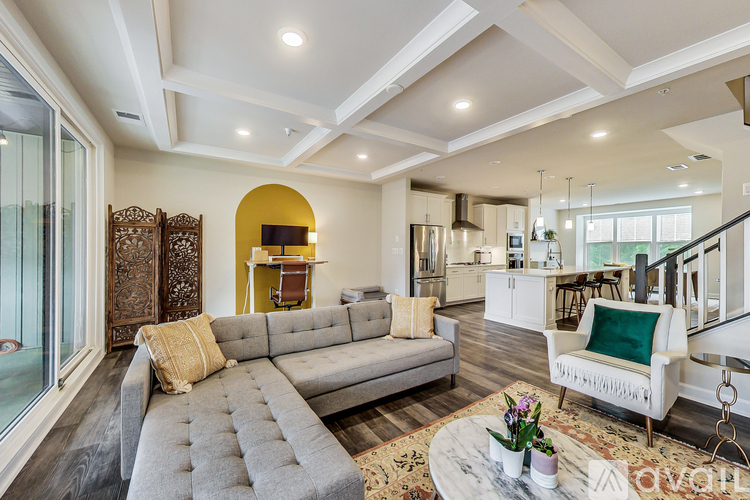 A living room with a grey sofa and a coffee table with flowers on it.