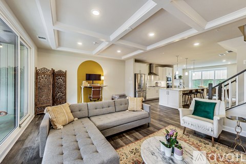 A living room with a grey sofa and a coffee table with flowers on it.