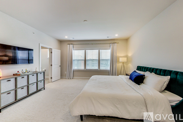 A bedroom with a large bed and a green headboard.
