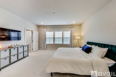 A bedroom with a large bed and a green headboard.