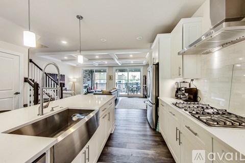 A modern kitchen with white cabinets and stainless steel appliances.