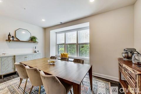 A dining room with a wooden table and chairs.
