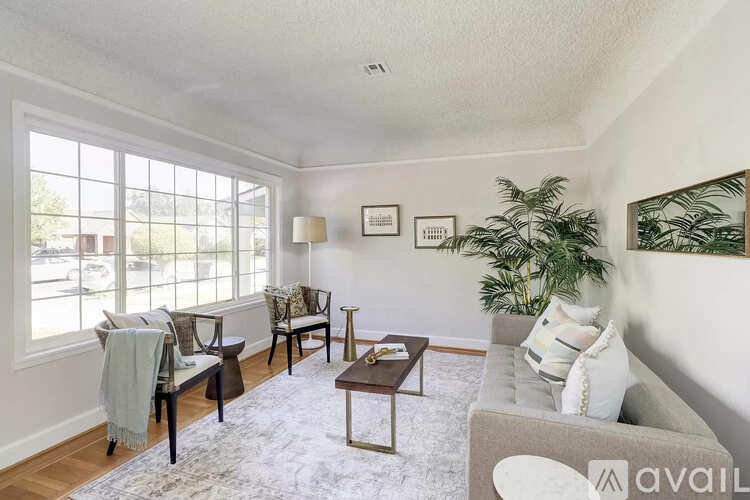 A living room with a couch, chairs, and a coffee table.