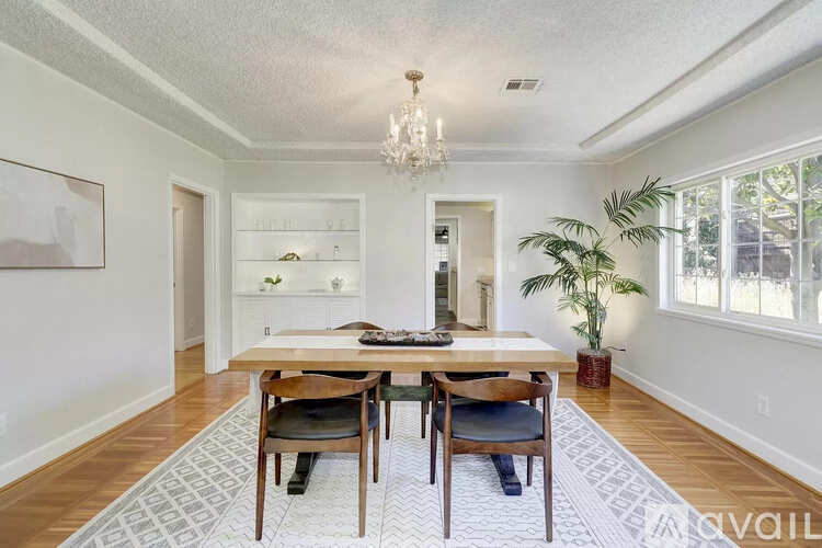 A dining room with a wooden table and chairs.