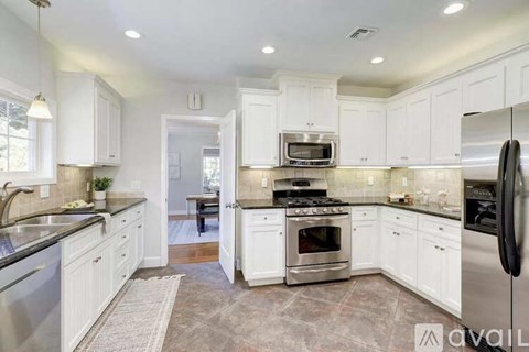 A kitchen with white cabinets and stainless steel appliances.