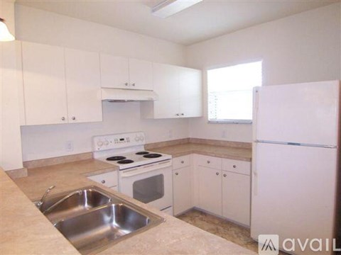 A kitchen with white cabinets and appliances.