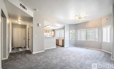 A spacious living room with a carpeted floor and a ceiling fan.