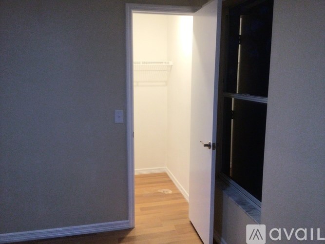 A hallway with a door on the right and a wall on the left.