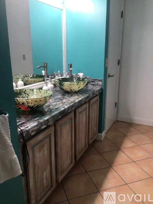 A bathroom with two sinks and wooden cabinets.
