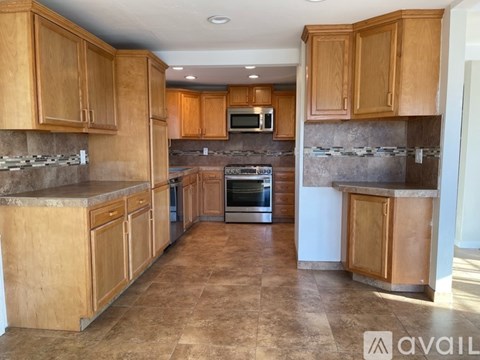 A kitchen with wooden cabinets and a tiled floor.