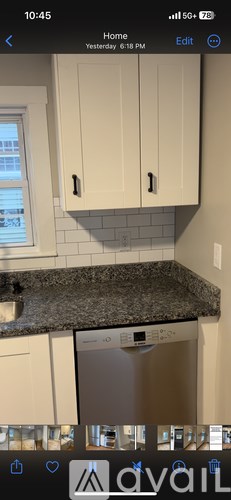 A kitchen with white cabinets and a granite countertop.