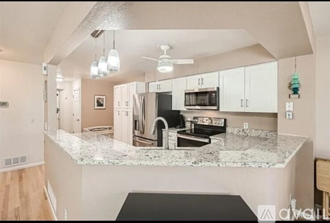 A kitchen with granite countertops and white cabinets.