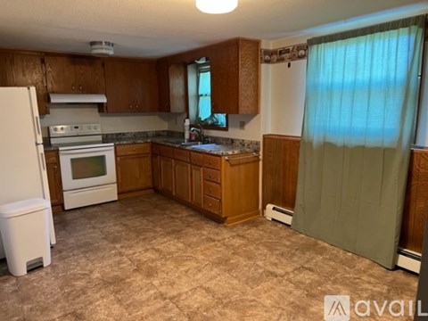 A kitchen with wooden cabinets and a white refrigerator.
