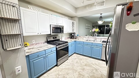 A kitchen with blue cabinets and a refrigerator.
