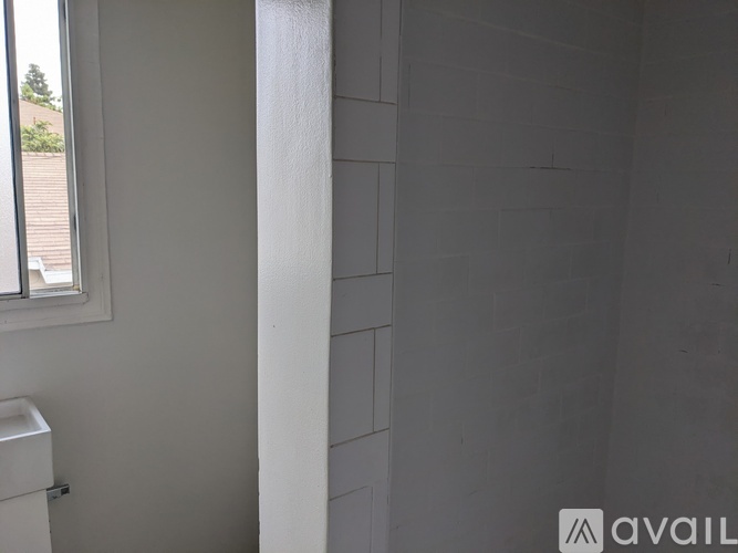A bathroom with a white sink and a window.