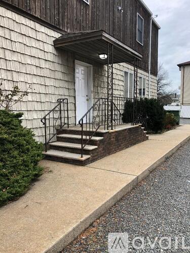 A house with a white door and a black metal railing on the steps.