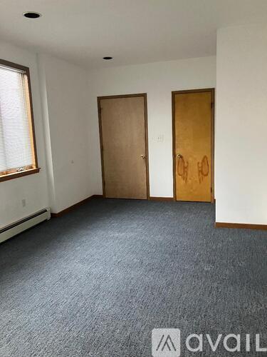 A room with two doors and a carpeted floor.