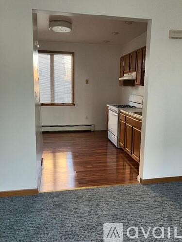 A kitchen area with a stove top oven and wooden cabinets.